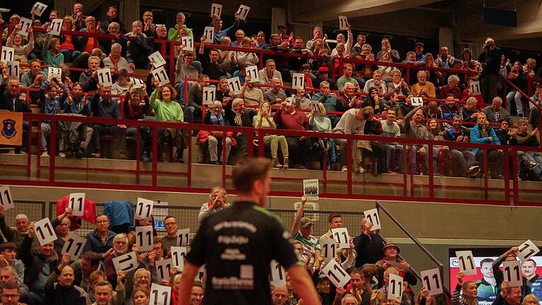 Nach jedem Satzgewinn eines Spielers des TSV Bad Königshofen hielt das Publikum Schilder mit der Zahl 11 hoch. Im Tischtennis geht ein Durchgang regulär bis elf Punkte.