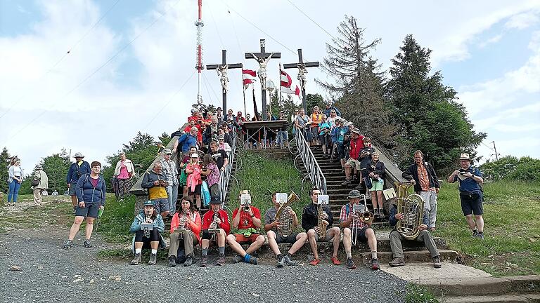 Gruppenbild der Pilgerinnen und Pilger aus Gräfendorf und Ebern an der Kreuzigungsgruppe mit der Musikgruppe aus Ebern und dem Tubisten aus Gräfendorf.