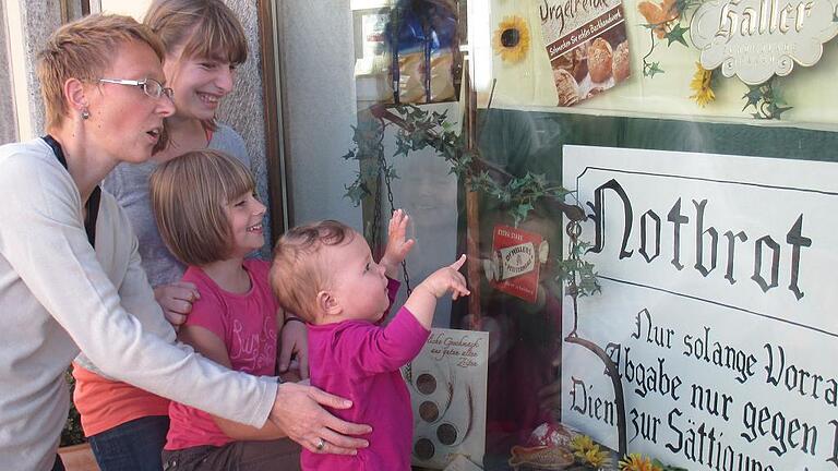 Nostalgie-Schaufenster       -  Das waren noch Zeiten: Margarete Karl mit ihrer kleinen Tochter Anna, Marie Krieger (Zweite von links) und Ida Krieger bestaunen, was es vor 50 Jahren in Auber Geschäften zu kaufen gab.