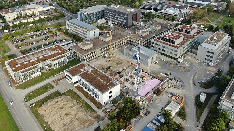 Übersicht über die Gebäude von Chemie und Pharmazie am Hubland. In der Mitte der noch zu sanierende Zentralbau. Im Bereich zwischen den beiden Baukränen entsteht das neue Praktikumsgebäude, auf der Wiese mit dem Erdhaufen (links vorne) das 'Center of Polymers for Life'.