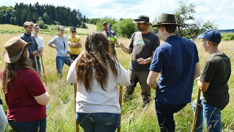 Kampf gegen Lupinen in der Rhön       -  Der Biologe Torsten Kirchner weist die Schüler in der Schornhecke ein.