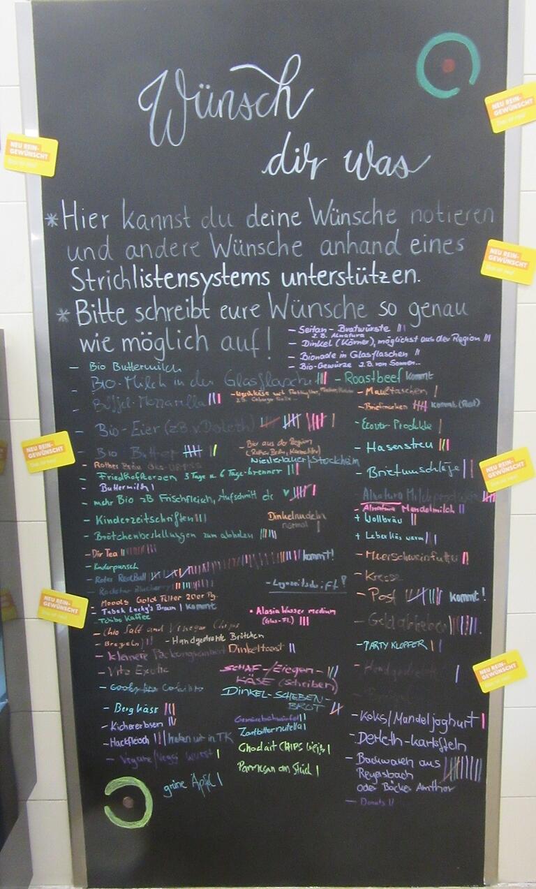 Auf der Wunschtafel in der Mitte des Ladens kann man noch die Waren eintragen, die mit ins Angebot aufgenommen werden sollten.