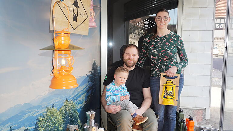 Familie Schmidt aus Fladungen hat ein Faible für Camping. Sie haben für die klassische Petroleumlampe einen Lampenschirm entwickelt. Im Schaufenster in Fladungen und im Internet zeigen sie ihr Sortiment. Das Bild zeigt Benedikt und Linda Schmidt mit Söhnchen Oliver.