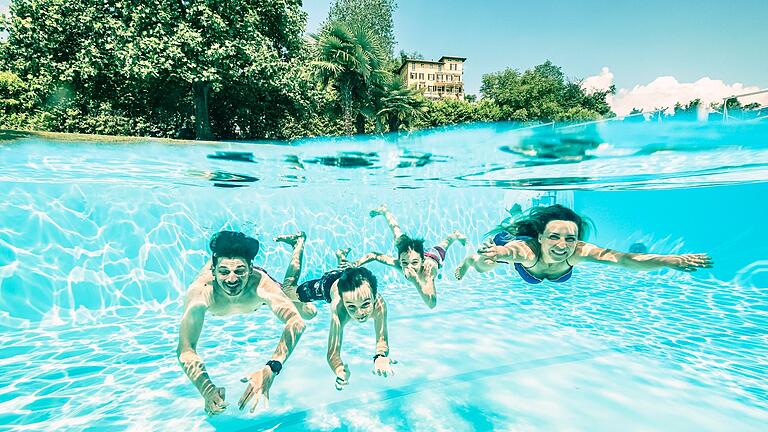 Familie schwimmt im Pool       -  Damit solche Aufnahmen nicht nur Profis mit teurer Ausrüstung gelingen, gibt es Unterwassergehäuse für Smartphones.