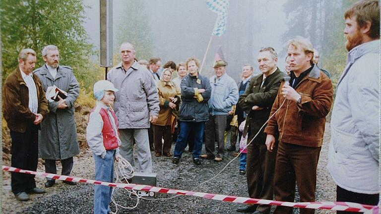 Freie Fahrt von Ost nach West: Ein Foto von der Grenzöffnung bei Weimarschmieden mit (vorne, von links) dem Brüchser Ortssprecher Richard Wetzel, dem Fladunger Stadtpfarrer Johannes Vogt, dem städtischen Angestellten Siegbert Lang, dem Fladunger Bürgermeister Raimund Goldbach sowie (am Mikrofon) Ortsteilbürgermeister Gensler aus Schafhausen. Freie Fahrt von Ost nach West: Ein Foto von der Grenzöffnung bei Weimarschmieden mit (vorne, von links) dem Brüchser Ortssprecher Richard Wetzel, dem Fladunger Stadtpfarrer Johannes Vogt, dem städtischen Angestellten Siegbert Lang, dem Fladunger Bürgermeister Raimund Goldbach sowie (am Mikrofon) Ortsteilbürgermeister Gensler aus Schafhausen.