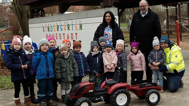 Christian Halbig (rechts kniend neben seiner Tochter) und Ludger Heydler übergaben einen Trettraktor an die Kinder des Kindergartens Hohestadt in Ochsenfurt und ihre Kindergartenleiterin Belkiz Almali.