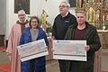 Pfarrer Helmut Rügamer und Kirchenpfleger Winfried Schraut (hinten) nehmen die Spendenschecks von Krimhild Hornschuch und Ernst Apfelbacher symbolisch in Empfang.