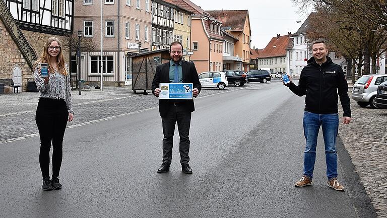 Kostenfrei ins Internet gelangen Einheimische und Gäste von Ostheim v. d. Rhön ab sofort mit dem BayernWLAN auf der Marktstraße von der Sparkasse bis zum Steinig. Über den zusätzlichen Service freuen sich Steffen Malzer, 1. Bürgermeister, Jessica Bott, zuständig für IT bei der Stadt Ostheim, sowie Pascal Kessler, Interkomm GmbH.