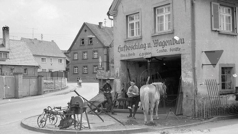 'Hufbeschlag und Wagenbau' – das historische Foto von Joachim Wiegmann aus den 1960er-Jahren zeigt die heute noch vorhandene Aufschrift über der Schmiede und den letzten aktiven Schmied Georg Kern, der noch bis in die 80er-Jahre tätig war. 'Hufbeschlag und Wagenbau' – das historische Foto von Joachim Wiegmann aus den 1960er-Jahren zeigt die heute noch vorhandene Aufschrift über der Schmiede und den letzten aktiven Schmied Georg Kern, der noch bis in die 80er-Jahre tätig war.