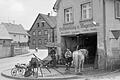'Hufbeschlag und Wagenbau' – das historische Foto von Joachim Wiegmann aus den 1960er-Jahren zeigt die heute noch vorhandene Aufschrift über der Schmiede und den letzten aktiven Schmied Georg Kern, der noch bis in die 80er-Jahre tätig war.