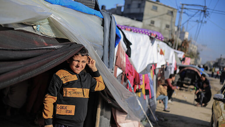 Nahostkonflikt - Rafah.jpeg - Ein vertriebenes palästinensisches Kind aus dem Norden von Gaza-Stadt steht vor einem provisorischen Zelt bei Rafah im Süden des Gazastreifens. Nahostkonflikt - Rafah.jpeg - Ein vertriebenes palästinensisches Kind aus dem Norden von Gaza-Stadt steht vor einem provisorischen Zelt bei Rafah im Süden des Gazastreifens.