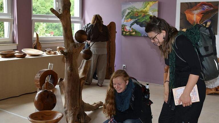 Waleria Sadkow und Johanna Owsian von der Holzbildhauerschule in Empfertshausen interessieren sich für die Objekte des Holzkünstler Jess Cobb. Foto: Andreas Lomb       -  Waleria Sadkow und Johanna Owsian von der Holzbildhauerschule in Empfertshausen interessieren sich für die Objekte des Holzkünstler Jess Cobb. Foto: Andreas Lomb