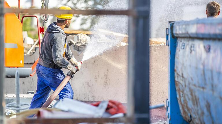 Die Arbeiter benetzen den Schutt mit Wasser, um die Staubbelastung der Umgebung zu minimieren.&nbsp;&nbsp;