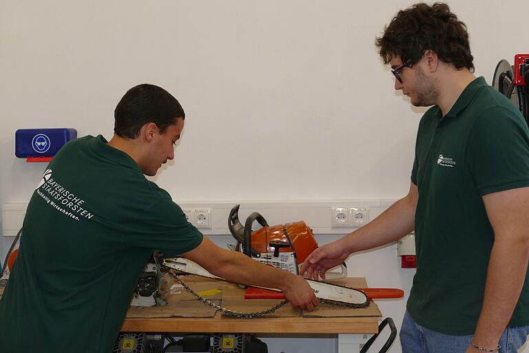 Im neuen Ausbildungszentrum der Bayerischen Staatsforsten in Arnstein ist alles Notwendige an Technik und Geräten vorhanden. Die Auszubildenden Christian Hartmann und Jakob Geiger richten eine Motorsäge ein.