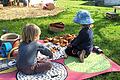 Träumen und Traumhäuser aus Holzklötzen bauen: Viele Kinder lieben es, auf einer bunten Decke im Gras zu sitzen und zu spielen.