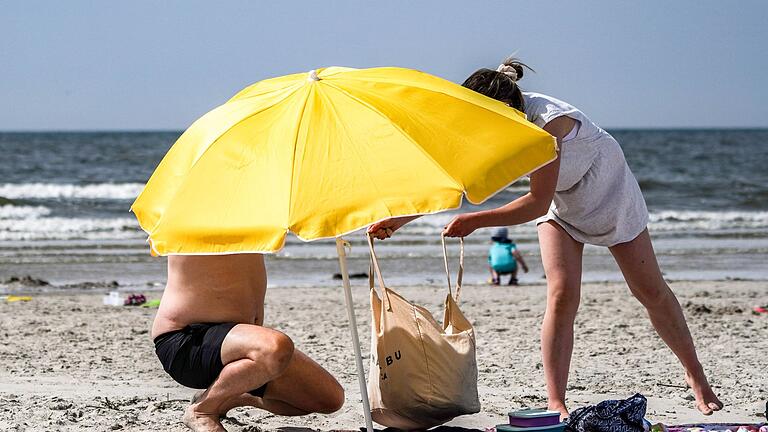 Sonnenschirm am Strand - Von der Reiselust profitieren auch die Urlaubsregionen im Inland - wie hier St. Peter-Ording in Schleswig-Holstein. Sonnenschirm am Strand - Von der Reiselust profitieren auch die Urlaubsregionen im Inland - wie hier St. Peter-Ording in Schleswig-Holstein.