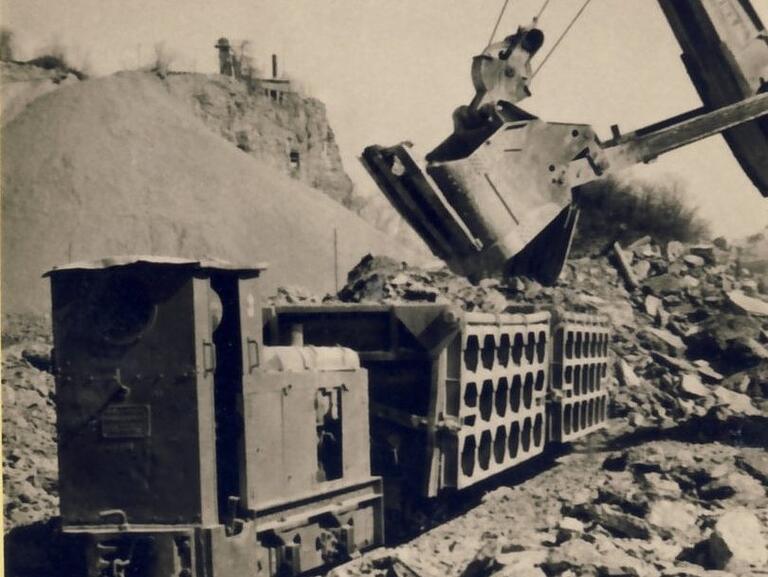 Der letzte Gleiseinsatz war 1958. Dann kamen die Lastwagen. Im Hintergrund der alte Steinbruch, der gerade mit Abraum rekultiviert wird. Oben auf dem Gutsberg der Schachtbrennofen. Der letzte Gleiseinsatz war 1958. Dann kamen die Lastwagen. Im Hintergrund der alte Steinbruch, der gerade mit Abraum rekultiviert wird. Oben auf dem Gutsberg der Schachtbrennofen.