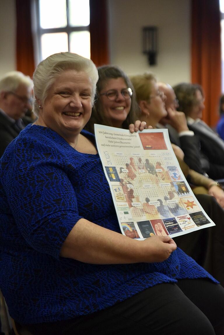 Diakonin Sabine Dresel (vorne) freute sich über das Plakat über gemeinsame ökumenische Veranstaltungen, das ihr Pastoralreferentin Claudia Nowak übergab.
