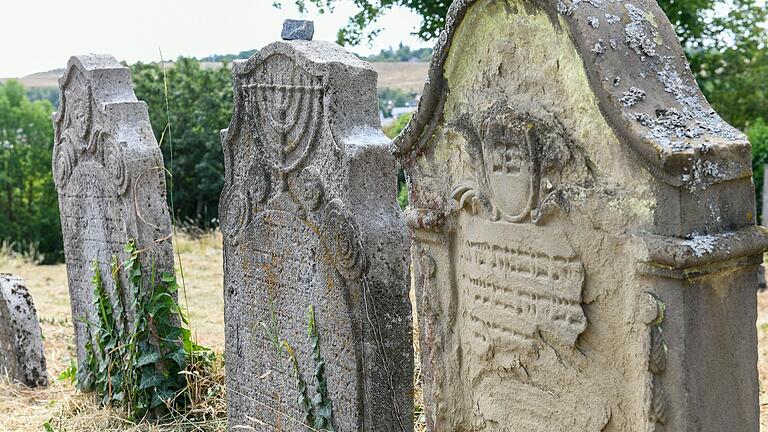 Symbole auf den Grabsteinen weisen auf die Aufgaben der Verstorbenen in ihrem irdischen Leben hin. Beispielsweise der Chanukka-Leuchter (Mitte), steht für jemanden, der in der Synagoge die Kerzen angezündet hat. Symbole auf den Grabsteinen weisen auf die Aufgaben der Verstorbenen in ihrem irdischen Leben hin. Beispielsweise der Chanukka-Leuchter (Mitte), steht für jemanden, der in der Synagoge die Kerzen angezündet hat. 