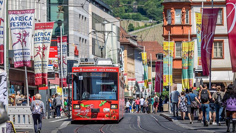 Eine Straßenbahn fährt durch die Würzburger Fußgängerzone. Eine Straßenbahn fährt durch die Würzburger Fußgängerzone.