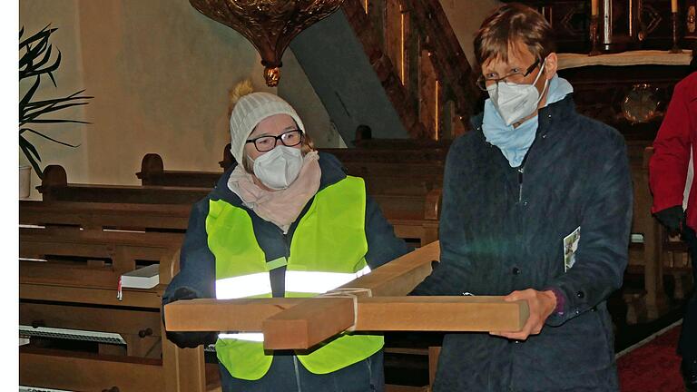 Beim Kreuzweg im Pastoralen Raum Bergtheim-Fährbrück wird ein Kreuz mitgetragen.