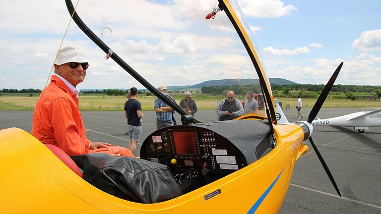 Im orangeroten Flieger-Combi entsteigt Uwe Nortmann seinem auf dem Kitzinger Flugplatz gelandeten Elektroflugzeug.