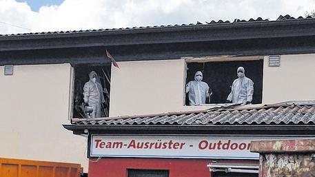 Arbeiter räumen das obere Stockwerk des Fahrradladens aus und werfen den Schutt aus dem Fenster.