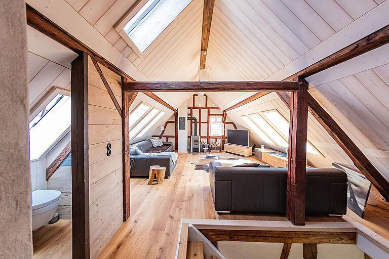 Blick in das Dachgeschoss des Hauses und das dortige Wohnzimmer: Durch die großen Dachfenster auf beiden Seiten fällt das Tageslicht herein. Blick in das Dachgeschoss des Hauses und das dortige Wohnzimmer: Durch die großen Dachfenster auf beiden Seiten fällt das Tageslicht herein.