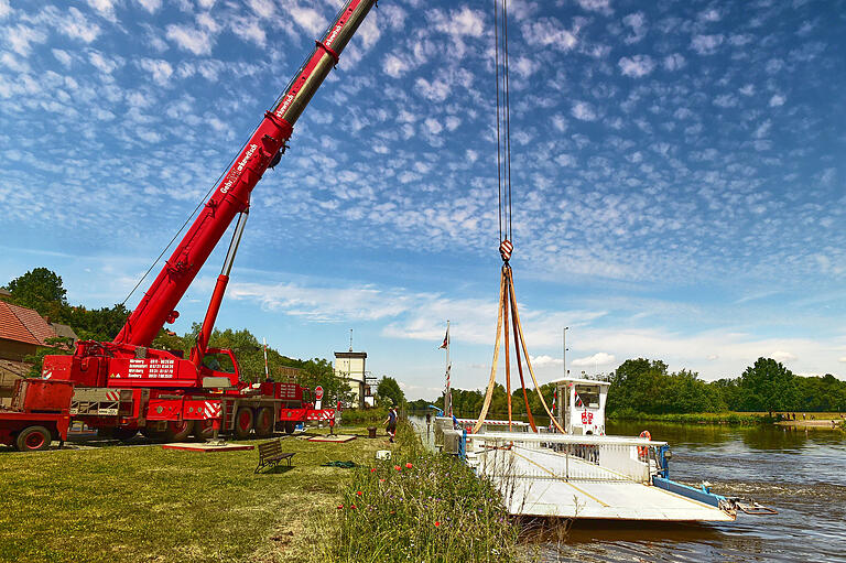 Bevor die Mainfähre mit dem Kran aus dem Wasser gehoben werden konnte, fuhr sie seitlich ans Ufer. Dann wurden zunächst die Rundschlingen befestigt.