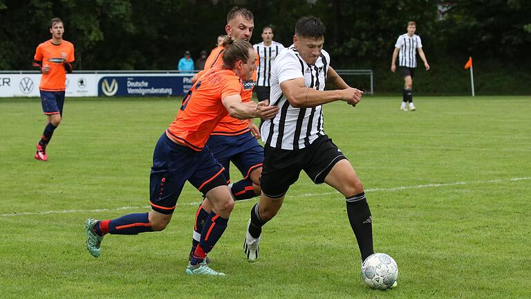 Thomas Bayer (rechts) vom FC Hopferstadt setzt sich in dieser Szene gegen Julian Kuchinka (links) und Jannik Scheblein von der SG Sommerhausen/Winterhausen durch. Durch ein Tor in der Nachspielzeit endete diese Kreisliga-Begegnung unentschieden.