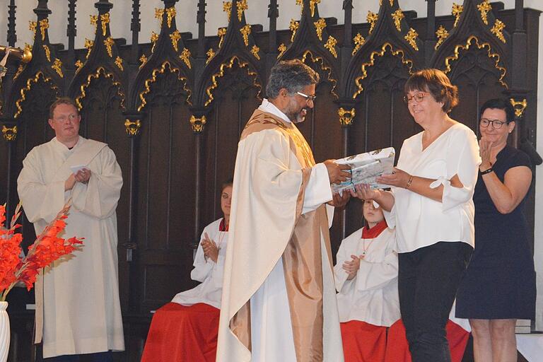 Pfarrgemeinderatsvorsitzende Sigrun Weigelt sagte dem scheidenden Pfarrer Pater Joe im Namen der Pfarreiengemeinschaft Grabfeldbrücke, der Kirchenverwaltungen und des Gemeindeteams Dank für seine Zeit in Bad Königshofen. Mit ihr war Anja Ankenbrand für den pastoralen Rat gekommen. Pfarrgemeinderatsvorsitzende Sigrun Weigelt sagte dem scheidenden Pfarrer Pater Joe im Namen der Pfarreiengemeinschaft Grabfeldbrücke, der Kirchenverwaltungen und des Gemeindeteams Dank für seine Zeit in Bad Königshofen. Mit ihr war Anja Ankenbrand für den pastoralen Rat gekommen.
