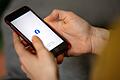 Logo der Facebook-App auf einem Smartphone       -  &bdquo;Watchlist Internet&rdquo; warnt vor betrügerischen Angeboten, besonders auf Facebook-Veranstaltungsseiten.