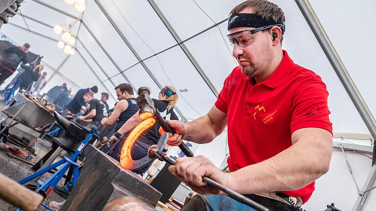 Der Schweizer Hufschmied Peter Brülisauer formt das glühende Hufeisen mit einem Hammer.