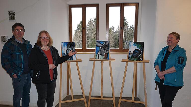 Doris Hopf zeigt im Bruder-Franz-Haus auf dem Kreuzberg in einer Ausstellung ihre Bilder des Bilderzyklus  'Das Leben Jesu'. Mit im Bild Bernhard Hopf und Carmen Zinßler-Maul vom Team des Bruder-Franz-Hauses (rechts). Foto: Marion Eckert       -  Doris Hopf zeigt im Bruder-Franz-Haus auf dem Kreuzberg in einer Ausstellung ihre Bilder des Bilderzyklus  'Das Leben Jesu'. Mit im Bild Bernhard Hopf und Carmen Zinßler-Maul vom Team des Bruder-Franz-Hauses (rechts). Foto: Marion Eckert