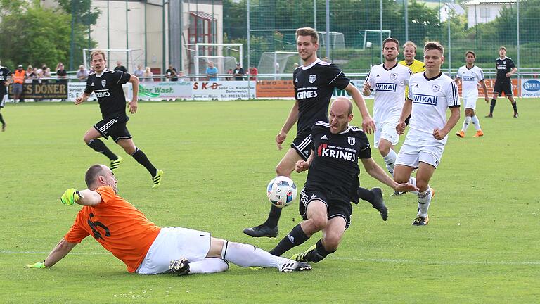 Sand- Erlenbach       -  Erlenbachs Keeper Sven Schröer ist einen Tick schneller am Ball als der Sander Florian Gundelsheimer. Gegen das 1:0 des Sander 4-ers war allerdings auch Schröer machtlos.