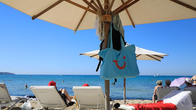 Tui-Tasche am Strand von Palma       -  Mallorca zählt in den Herbstferien wieder zu den beliebten Resiezielen der Tui-Urlauber, ist aber nicht mehr auf Platz eins. (Archivbild)