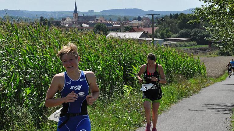 28. Hofheimer Triathlon bei viel Wind und Wärme       -  (msch)   Temperaturen von teilweise jenseits der 30-Grad-Marke und teils böiger Wind verlangten den Teilnehmern des 28. Triathlons am Sonntag einiges ab. 87 Athleten wagten sich an die Mitteldistanz, den halben &bdquo;Iron Man&ldquo;. 73 Sportler gingen bei der olympischen Kurzdistanz an den Start, 128 absolvierten den Sprint-Triathlon. Außerdem gingen 14 Staffeln an den Start, sodass 330 Triathleten schwammen, Rad fuhren und liefen. Der Hamburger Benjamin Dicke gewann die Königsdisziplin, die Mitteldistanz mit 1,9 Kilometer Schwimmen, 94,6 Kilometer Radfahren und 20,4 Kilometer Laufen in etwas mehr als 4 Stunden. Dicke ist vor zwei Monaten in die Nähe von Nürnberg gezogen und startete das erste Mal beim Hofheimer Triathlon. Er und viele andere Athleten lobten die schöne Strecke, die familiäre Atmosphäre und die tolle Organisation. Ein ausführlicher Bericht folgt in der morgigen Ausgabe.