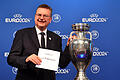 Bekanntgabe EM-Gastgeber 2024       -  27.09.2018, Schweiz, Nyon: Fußball Bekanntgabe des EM-Gastgebers 2024: DFB-Präsident Reinhard Grindel von der deutschen Delegation hält einen Zettel mit 'Germany' neben dem EM-Pokal während der Bekanntgabe-Zeremonie zur Ausrichtung der Fußball-Europameisterschaft 2024. Deutschland ist Gastgeber der Fußball-EM 2024. Um die Ausrichtung der EM 2024 hatten sich die Fußball-Verbände aus Deutschland und der Türkei beworben. Foto: Soeren Stache/dpa +++ dpa-Bildfunk +++