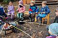 Kinder des Waldkindergartens an der Feuerstelle.