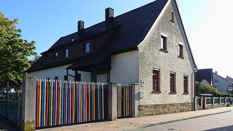 So sieht der Kindergarten Kützberg zur Zeit aus. Der auffällige 'Buntstift-Zaun' lässt auf den ersten Blick nicht erahnen, dass das Gebäude nicht mehr den Anforderungen entspricht. Die Gemeinde hat inzwischen das Grundstück erworben und möchte die Kita neu bauen. Wie es aber mit dem Trägerverein weitergeht, ist unklar. Die Vorsitzende ist zurückgetreten.&nbsp;