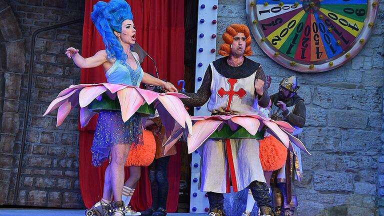 Ritter Galahad (Péter Polgár) und die Fee aus dem See (Antje Rietz) im Blümchenkleid auf Rollschuhen. Die Artus-Parodie &bdquo;Spamalot&ldquo; nimmt mit vielen Anspielungen auch das Genre auf die Schippe, wie in dieser Szene das Musical &bdquo;Starlight Express&ldquo;. Das Röttinger Premierenpublikum war begeistert.