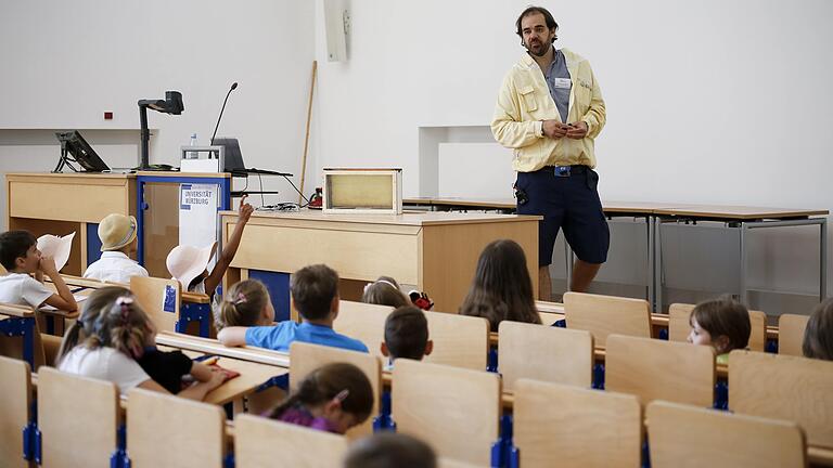 Etwa 370 Kinder verfolgen am Samstag (29.06.19) bei der Kinderuni im Audimax der Universität am Sanderring in Würzburg den Vortrag von Dr. Thomas Münz (Lehrstuhl für Verhaltensphysiologie und Soziobiologie) über Bienen und ihr Sozialverhalten. Etwa 370 Kinder verfolgen am Samstag (29.06.19) bei der Kinderuni im Audimax der Universität am Sanderring in Würzburg den Vortrag von Dr. Thomas Münz (Lehrstuhl für Verhaltensphysiologie und Soziobiologie) über Bienen und ihr Sozialverhalten.