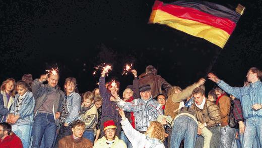 Jubelfeier: Mit der Fall der Berliner Mauer am 9. November 1989 öffnet sich auch das Tor zur deutschen Einheit.