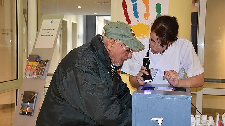 Hände gründlich gewaschen? Schwester Simone zeigt einem Besucher unter der UV-Lampe, ob noch Bakterien zu finden sind auf seinen frisch gewaschenen Händen. Hände gründlich gewaschen? Schwester Simone zeigt einem Besucher unter der UV-Lampe, ob noch Bakterien zu finden sind auf seinen frisch gewaschenen Händen.