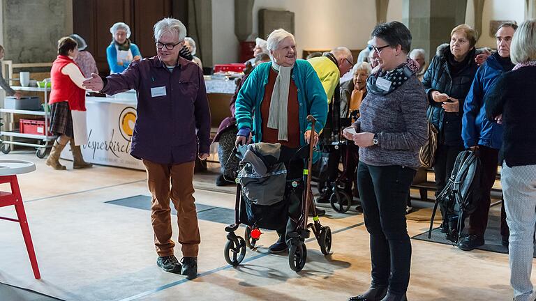 Ein paar nette Worte und die Begleitung hin zum Platz gehören einfach dazu bei der Vesperkirche. Als 'Reporter in Betrieb' hatte Helmut Glauch (links) die Aufgabe die Gäste zu ihren Plätzen zu begleiten und eventuell den Rollator sicher unterzubringen oder aus der Jacke zu helfen.