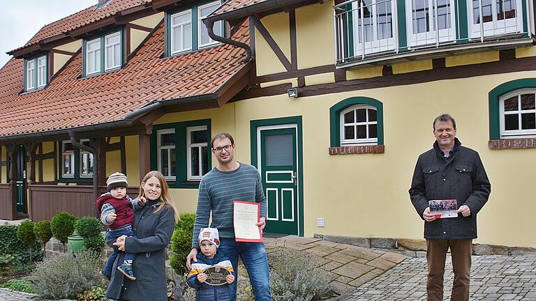Freuen sich über die Auszeichnung des Bezirks Unterfranken mit dem Förderpreis, wofür es Urkunde und eine Plakette gab, die noch angebracht werden muss. Unser Bild zeigt von links: Yvonne mit Nils und Phil, der stolz die Plakette  präsentiert, Steffen Werner und Bürgermeister Thomas Helbling.