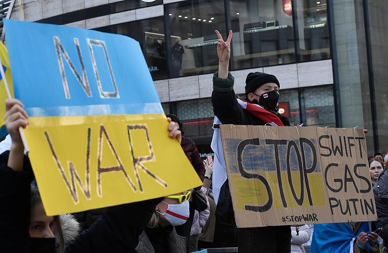 Demonstranten halten in Düsseldorf Schilder mit der Aufschrift 'No War' und 'Stop Swift, Gas, Putin'. Mehrere hundert Menschen demonstrierten auf dem Schadowplatz gegen Russlands Angriff auf die Ukraine.