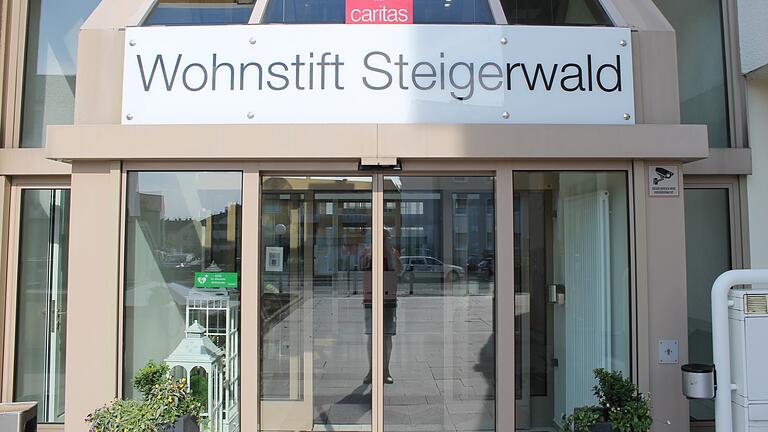 Am Haupteingang des Wohnstifts Steigerwald weist links ein grünes Schild darauf hin, dass hier ein&nbsp;Automatisierter Externer Defibrillator (AED) stationiert ist.