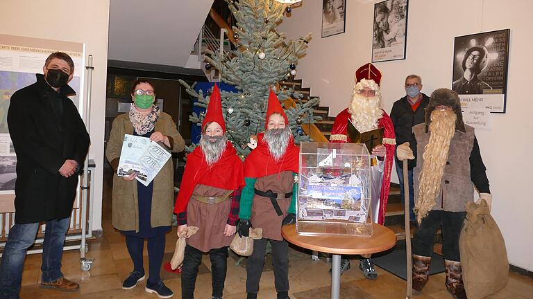Bevor sich der Nikolaus mit Knecht Ruprecht auf die Socken machte, um die angemeldeten Kinder zu besuchen, zogen die Wichtel Janne Krieg und Hennes Kleinert die Glückslose. Mit im Bild Bürgermeister Michael Kraus, AM-Geschäftsführerin Brigitte Proß und AM-Vorsitzender Wolfgang Pfeiffer (hinten rechts). Bevor sich der Nikolaus mit Knecht Ruprecht auf die Socken machte, um die angemeldeten Kinder zu besuchen, zogen die Wichtel Janne Krieg und Hennes Kleinert die Glückslose. Mit im Bild Bürgermeister Michael Kraus, AM-Geschäftsführerin Brigitte Proß und AM-Vorsitzender Wolfgang Pfeiffer (hinten rechts).
