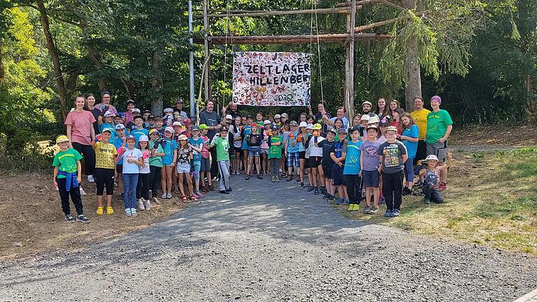 Stellvertretender Landrat Josef Demar und Lagerleitung Ekkehard Schmitt hissen gemeinsam mit den Hillenbergkids die Lagerfahne.